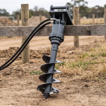 Hydraulic auger drive with a 12 inch spiral bit standing upright at a fencing site
